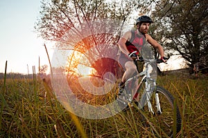 Determined young man riding mountain bike in a park