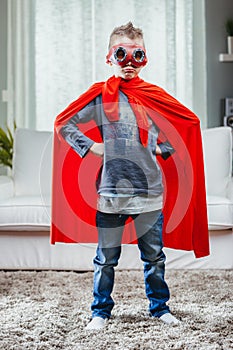 Determined young Super Hero in a colorful red cape