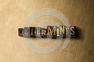 DETERMINES - close-up of grungy vintage typeset word on metal backdrop