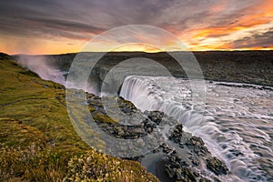 Detifoss waterfall with sunset in the background