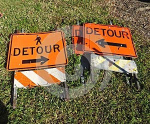 Detour signs lying in grass