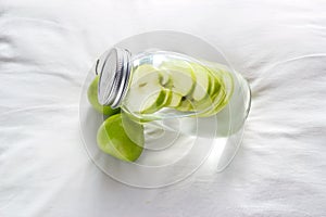Detox diet fresh green apples soak in water of the jar photo