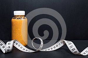 Detox drink with dumbbells and measuring tape. Free space for text. Concept: detox and fitness, diet and exercises