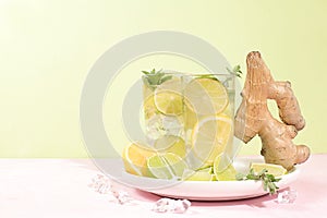 Detox drink with lemon, mint, lime, ginger and orange on a light table, cocktail improves metabolism and promotes weight loss,