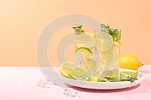 Detox drink with lemon, mint, lime and orange on a light table, mojito or cocktail improves metabolism and promotes weight loss