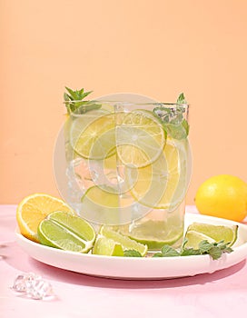 Detox drink with lemon, mint, lime and orange on a light table, mojito or cocktail improves metabolism and promotes weight loss