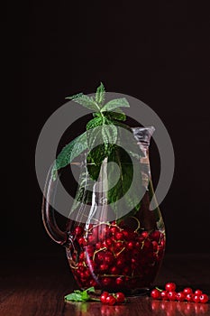 Detox drink with red currants berries and mint in glass jug