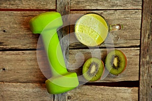 Detox food with kiwi smootie and a green lifting weight photo