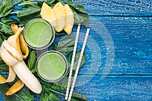 Detox green smoothie with spinach, pineapple, banana and yogurt, flat lay, copy space