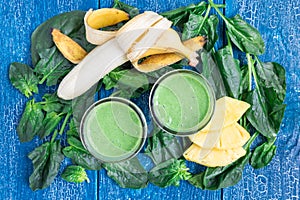 Detox green smoothie with spinach, pineapple, banana and yogurt, top view