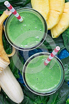 Detox green smoothie with spinach, pineapple, banana and yogurt, top view, closeup
