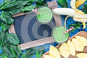 Detox green smoothie with spinach, pineapple, banana and yogurt, top view, copy space