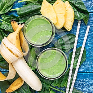 Detox green smoothie with spinach, pineapple, banana and yogurt, top view, square