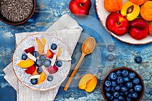 Detox and healthy superfoods breakfast bowl concept. Vegan coconut milk chia seeds pudding over rustic table with various fruits