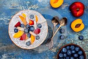 Detox and healthy superfoods breakfast bowl concept. Vegan coconut milk chia seeds pudding over rustic table with various fruits