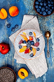 Detox and healthy superfoods breakfast bowl concept. Vegan coconut milk chia seeds pudding over rustic table with various fruits