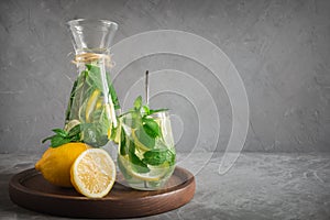 Detox lemonade with mint, citrics in glass on grey background