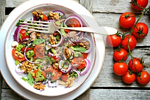 Detox , vegan , raw salad with tomatoes , onions and walnuts photo