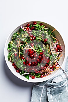 Detox vegan salad with kale, vegetables, pomegranate and tahini dressing