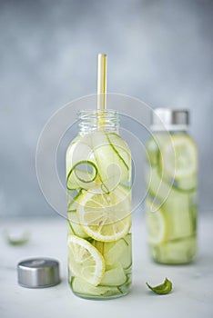 detox water with cucumber, lemon and mint in a tall glass bottle