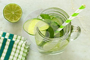 Detox water with lime and cucumbers above view in jar