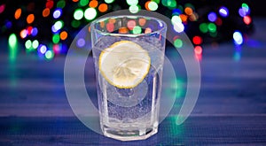 Detox after winter party. Health care concept. What to drink on christmas party. Cocktail glass with water and slice of