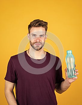 Detoxifies. handsome guy hold water bottle. hydration and hydro-balance. sport and health. refreshing while fitness