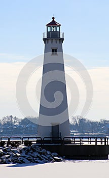 Detroit riverfront lighthouse during cold winter facing Canada