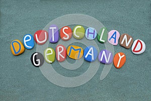 Deutschland, Germany, souvenir composed with multi colored stone letters over green sand