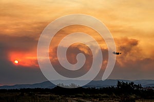 Devastating wildfire in Alexandroupolis Evros Greece, Aerial firefighting waterbombing planes, smoke covered the sky, sunset photo