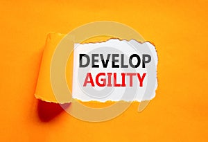Develop agility symbol. Concept words Develop agility on beautiful white paper on a beautiful orange background. Business, support