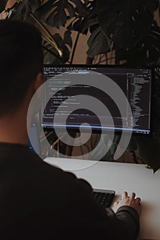 Developer is coding using screen and tablet. Freelancer is working from home