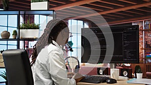 Developer at computer desk coding while listening music