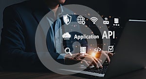 Developer interacting with API and cloud technology icons on a laptop