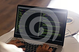 Developer programmer writing html javascript code in a laptop.