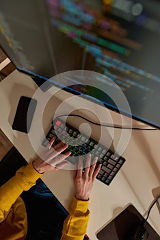 IT developer typing code on computer at home