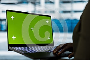 Developer uses green screen laptop to do checkup on data center electronics