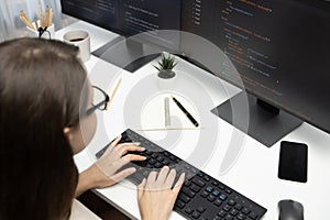 IT developer woman coding on laptop screen at back side view. Postulate.