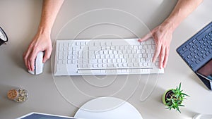 The developer works at the computer, typing, uses the mouse. Selective focus