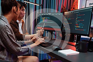 IT developers discussing with point website coding system. Infobahn.