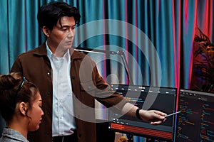 IT developers discussing with point website coding system. Infobahn.