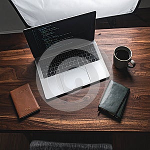Developers Wooden Desk with Code on Screen