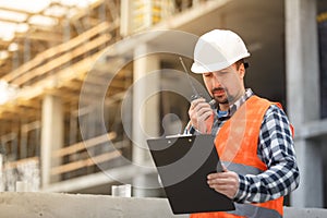 Developing engineer wearing white safety vest and hardhat with w