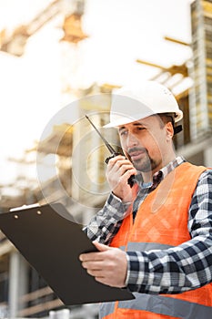 Developing engineer wearing white safety vest and hardhat with w