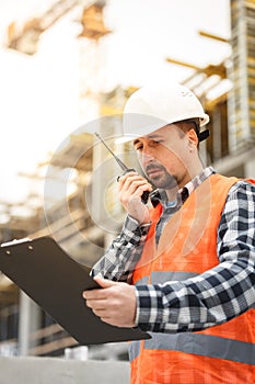 Developing engineer wearing white safety vest and hardhat with w