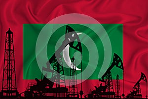 Developing Flag of Maldives. Silhouette of drilling rigs and oil rigs on a flag background. Oil and gas industry. The concept of