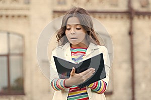 Developing her reading skills. Little girl read book outdoor. Small kid enjoy reading day. Adorable bibliophile. Child