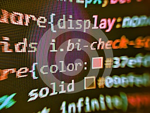 Developing HTML and technology. Black background with colored lines of code. Information technology website coding standards for