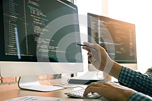 Developing programming working in a software engineers code tech applications on desk in office room