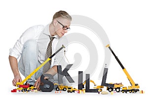 Developing skills: Businessman building skill-word photo